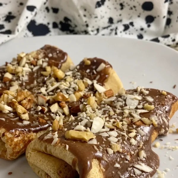 Crepes rellenos con crema proteica de chocolate y nueces picadas, receta saludable de MAKEITGRAIN